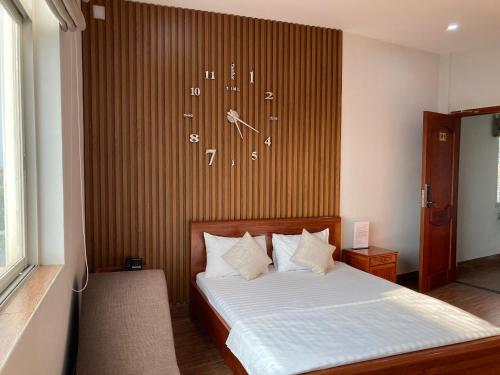 una camera da letto con un letto con un orologio sul muro di Nguyên Thái II ad Ho Chi Minh