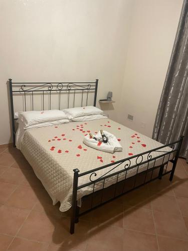 a bed with a white bedspread with red flowers on it at Tommy House 19 in Focene