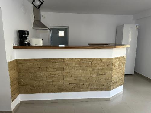 a kitchen with a brick wall with a counter top at Cabana Sarmis Costesti in Costeşti