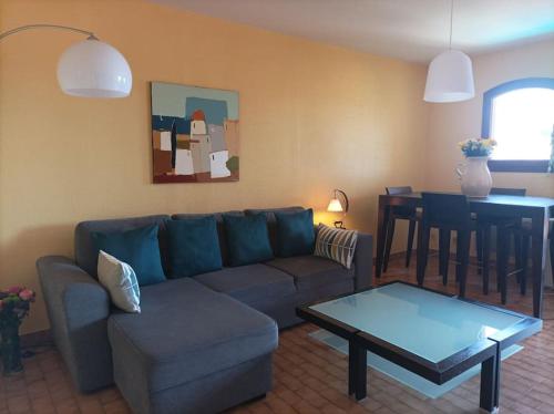 a living room with a couch and a table at Collioure, entre mer, piscine & montagne in Collioure