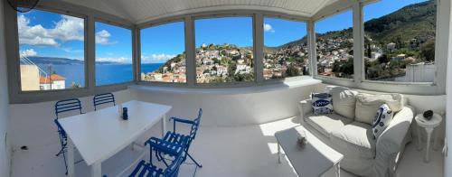 a room with a table and chairs and a view of the ocean at Louisa’s View in Hydra