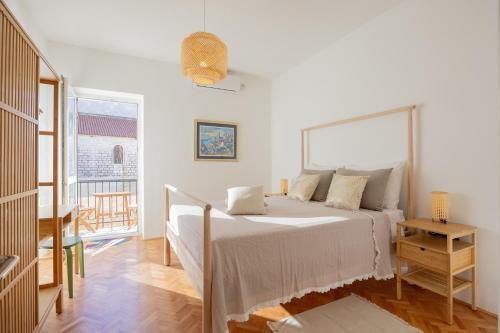 ein weißes Schlafzimmer mit Bett und Balkon in der Unterkunft Zadar Center Apartment in Zadar