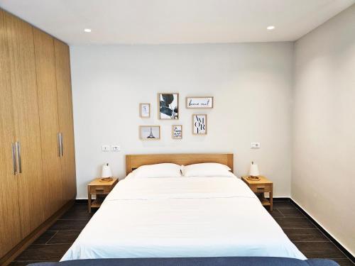 ティラナにあるMagnet Residence Condo 3 self check inのベッドルーム1室(大きな白いベッド1台、サイドテーブル2台付)