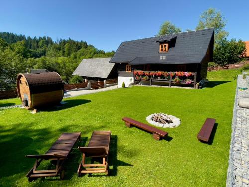 a backyard with benches and a building with a fire pit at Traditional deer Cabin with Sauna in Dolný Kubín