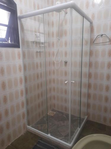 um chuveiro com uma porta de vidro na casa de banho em Cantinho da Lagoa em Araruama