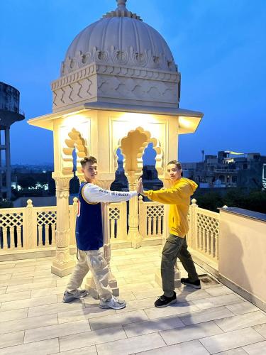two men are shaking hands in front of a building at Gupta Vilas - A Boutique Homestay in Agra