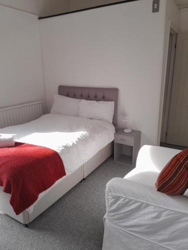 a bedroom with two beds and a red blanket at SINGLETON SHORT STAYS R8 in Swansea
