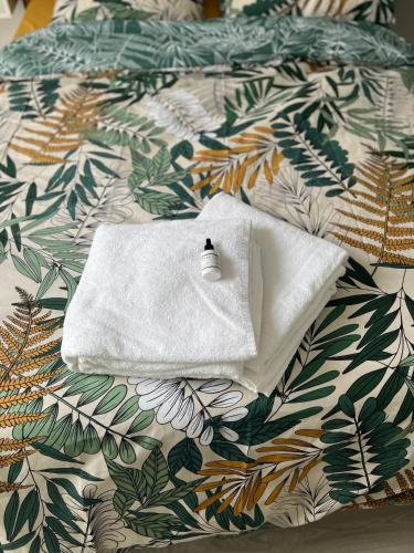 - une serviette blanche assise au-dessus du lit dans l'établissement Superbe 3 pièces avec balcon pour 5 personnes, à Villiers-le-Bel