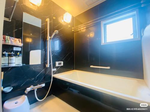 a bathroom with a bath tub and a window at Umeda Yodogawa Cozy Home A 步行到JR站5分钟 大阪梅田1站 新大阪2站 京都 神户直达 USJ地铁25分钟 in Osaka
