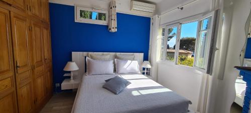 Villa Adriandre في لو رايول-كاناديل-سور-مير: غرفة نوم زرقاء مع سرير بجدار ازرق
