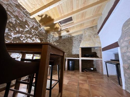 a kitchen with a bar and a stone fireplace at Casa Rural La Garcia in Puebla de Arenoso