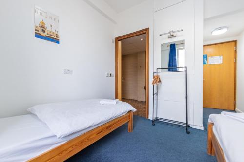 a small room with two beds and a door at Pax Lodge in London