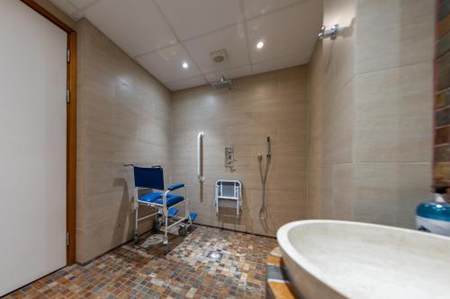 y baño con ducha, bañera y silla. en Pax Lodge, en Londres