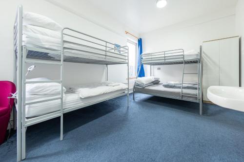 two bunk beds in a room with a sink at Pax Lodge in London