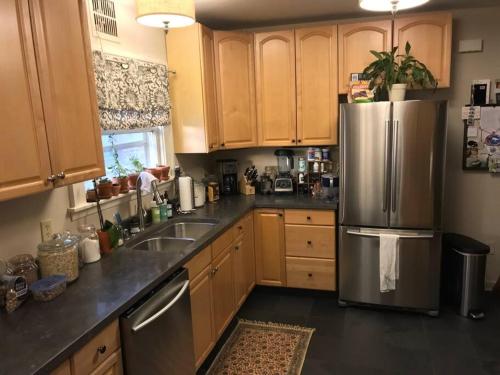 a kitchen with wooden cabinets and a stainless steel refrigerator at Beautiful Luxury Suite A of Shorewood Home in Shorewood