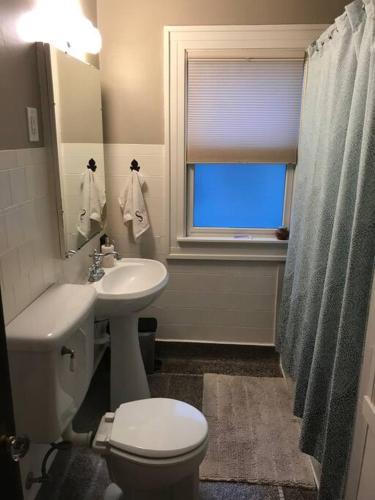 a bathroom with a sink and a toilet and a window at Beautiful Luxury Suite A of Shorewood Home in Shorewood
