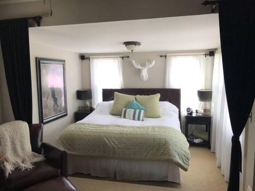a bedroom with a large bed and two windows at Beautiful Luxury Suite A of Shorewood Home in Shorewood