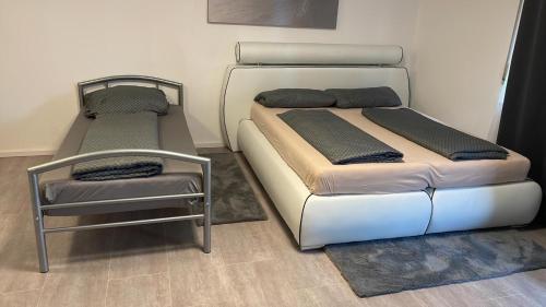 dwa łóżka i krzesło w pokoju w obiekcie Ferienwohnung Panoramablick w mieście Sinsheim
