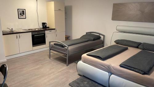 ein kleines Zimmer mit 2 Betten und einer Küche in der Unterkunft Ferienwohnung Panoramablick in Sinsheim