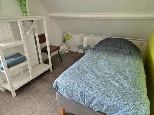 a bedroom with a bed and a table and a chair at vrijstaande ruime familiewoning landelijk gelegen in Lewedorp