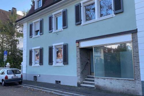 a white house with windows and a car parked outside at Zentrale Stadtwohnung, Bahnhofsnähe, OG-Krankenhaus, OG-Messe, EuropaPark in Offenburg