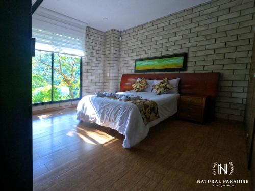 a bedroom with a bed and a brick wall at Home Boutique Natural Paradise in La Vega