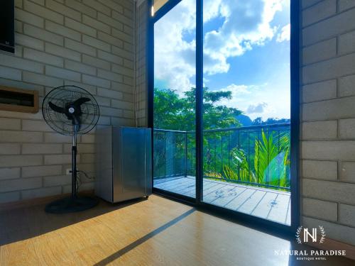a room with a fan and a glass door at Home Boutique Natural Paradise in La Vega