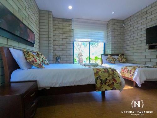a bedroom with two beds and a television in it at Home Boutique Natural Paradise in La Vega