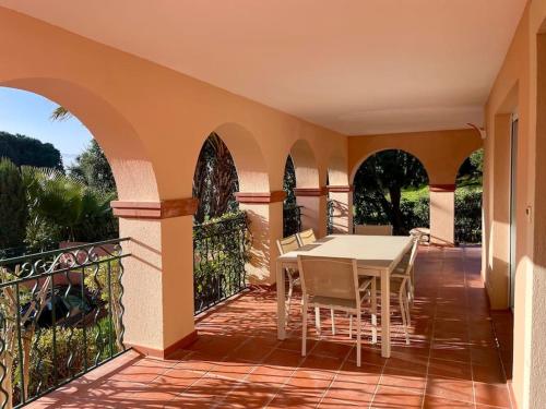 eine Terrasse mit Tisch und Stühlen auf einem Balkon in der Unterkunft Villa 49 Hameau des Greens in Sainte-Maxime