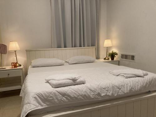 um quarto com uma cama com toalhas em דירה נעימה לזוג בין נווה צדק לנחלת בניימין em Tel Aviv