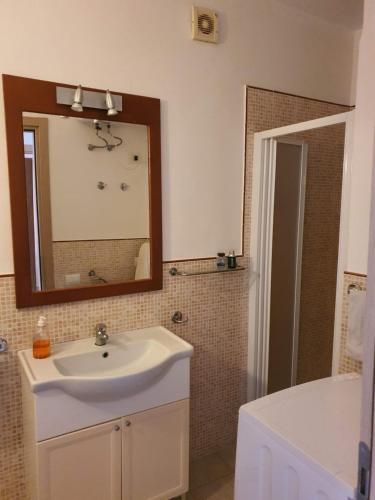a bathroom with a white sink and a mirror at Casa Verde in Santa Maria