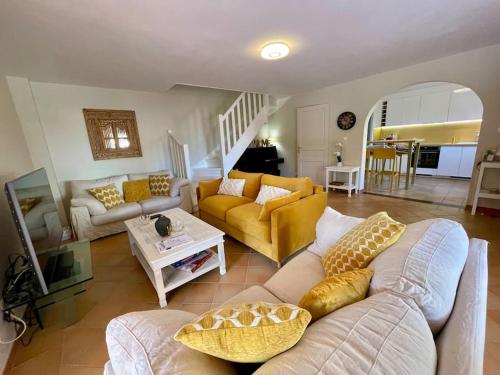 ein Wohnzimmer mit Sofa und Tisch in der Unterkunft Villa 49 Hameau des Greens in Sainte-Maxime