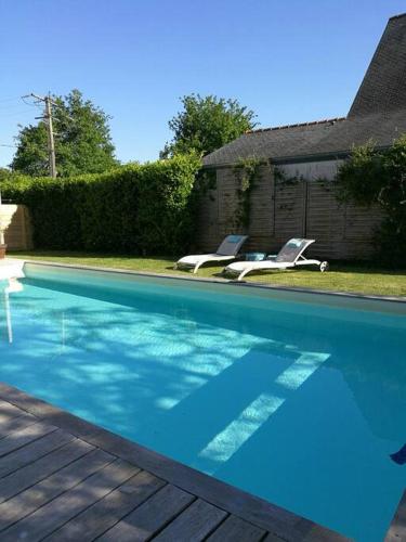 - une piscine avec 2 chaises longues à côté d'une maison dans l'établissement T2 jardin privatif et accès piscine, à Ploeren