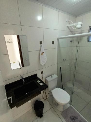 a bathroom with a toilet and a sink and a shower at Pousada Bsm in Barra de São Miguel