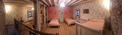 FontainebruxにあるLa Grange de Félixのベッド2台と階段が備わる小さな客室です。