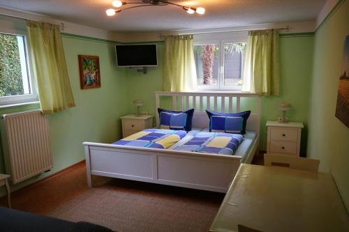Schlafzimmer mit einem Bett mit blauen und gelben Kissen in der Unterkunft Gästezimmer Sieg in Rust