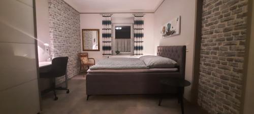 a bedroom with a bed and a brick wall at Bauernhaus Schunck im Bliesgau in Blieskastel