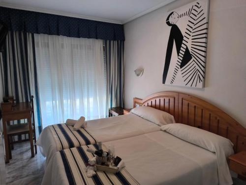 a bedroom with a large bed and a picture on the wall at Hotel Arillo in Noja