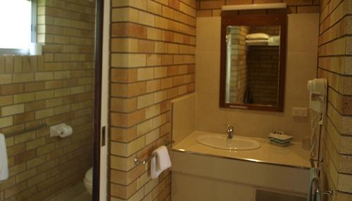 La salle de bains est pourvue d'un lavabo et d'un miroir. dans l'établissement Pacific Paradise Airport Motel, à Pacific Paradise 