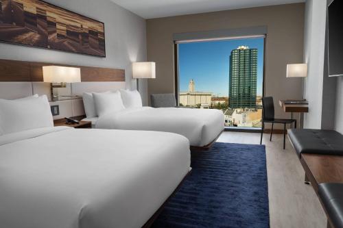 a hotel room with two beds and a large window at AC Hotel by Marriott Austin-University in Austin