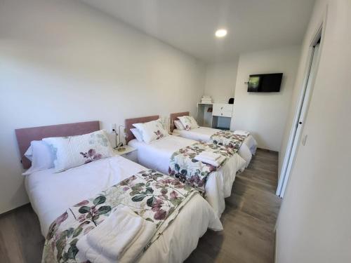 Louridoplaya في بويو: سريرين في غرفة بجدران بيضاء وأرضية خشبية