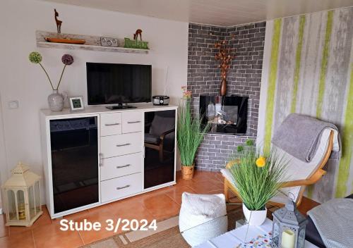 salon z telewizorem i kominkiem w obiekcie Bungalow Thiele w mieście Döbeln
