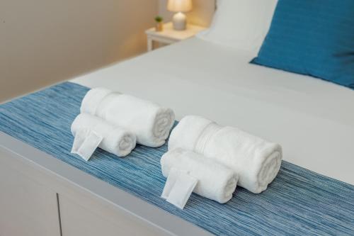 eine Gruppe gerollter Handtücher auf einer Theke neben einem Bett in der Unterkunft Bonfim Premium by Hosty in Porto