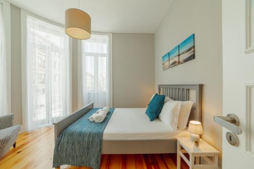 ein Schlafzimmer mit einem großen Bett mit blauen Kissen in der Unterkunft Bonfim Premium by Hosty in Porto