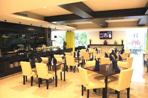 a restaurant with tables and chairs and a bar at Bonnet Hotel Surabaya in Surabaya