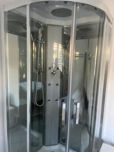 a shower with glass doors in a bathroom at Mayfield guest rooms in Bromley