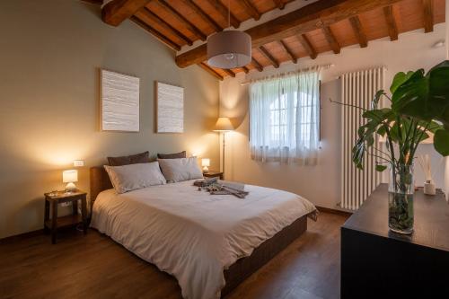 a bedroom with a large bed and a window at Il Cipresso del Fossaccio in Asciano