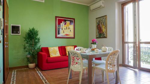 Una sala de estar con una mesa y un sofá rojo. en New Alguerhouse, en Alghero