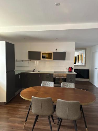 een keuken met een houten tafel en stoelen bij Tondose Apartment in Dortmund