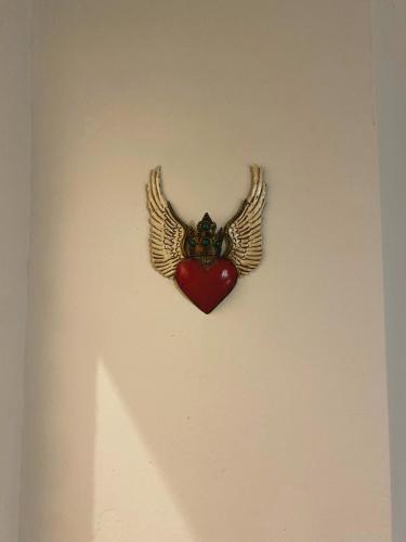a heart with wings on a wall with a heart with a heart with a heart at Mestizo Antigua Cortijo in Ciudad Vieja
